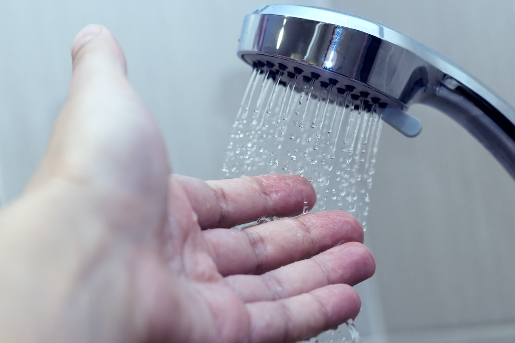 Hand checking shower water temperature | Terry's Plumbing Pittsburgh